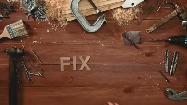Вид сверху на временной промежуток руки, лежащей на влажном столе со словами "FIX IT" " — стоковое видео