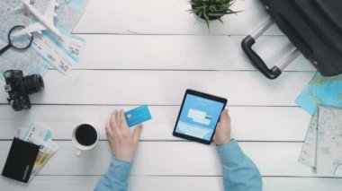 Üstten Görünüm yolcuları eller için uçak bileti hattı Beyaz ahşap masa başında dijital tablet ve kredi kartı ile ödeme