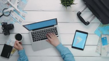 Üstten Görünüm yolcuları el Beyaz ahşap masanın üzerinde yatan harita ile dizüstü bilgisayar dijital tablet kullanma
