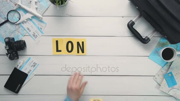 Ovanifrån tidsfördröjning händer handpåläggning vita skrivbord word "London" dekorerad med resor artiklar — Stockvideo