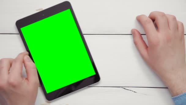 Vue du dessus mains masculines montrant plusieurs gestes sur tablette numérique avec écran vert au bureau blanc de l'espace de copie au-dessus — Video