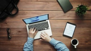Üstten Görünüm erkek büyük veri grafikleri yukarıdan beyaz masa üzerinde yalan ile dizüstü bilgisayar ve dijital tablet üzerinde çalışan eller