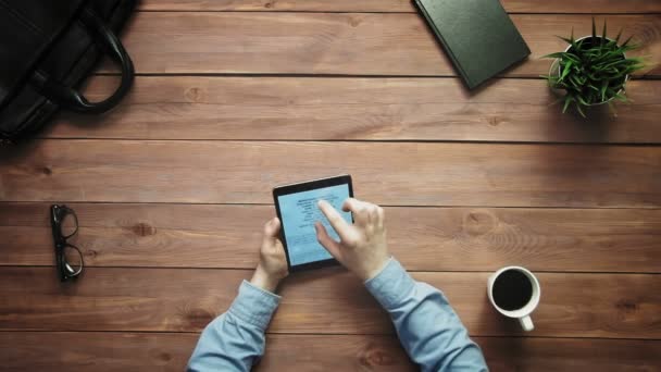 Bovenaanzicht mannelijke handen werken met digitale tablet kijken naar grote gegevens grafieken en diagrammen aan witte Bureau van bovenaf — Stockvideo