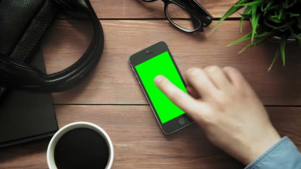 Top view male hands showing multiple gestures on smartphone with green screen at white desk from above — Stock Video