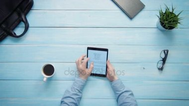 Üstten Görünüm erkek büyük veri grafikler ve beyaz masa yukarıdan bakarak dijital tablet ile çalışan eller