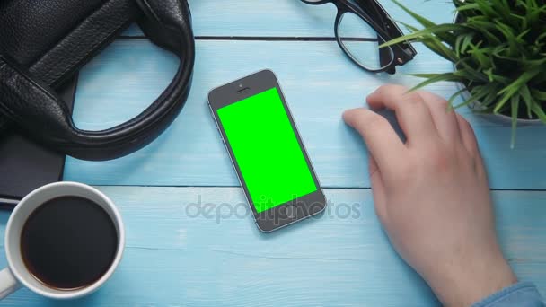 Top vista mãos masculinas mostrando vários gestos no smartphone com tela verde na mesa branca de cima — Vídeo de Stock