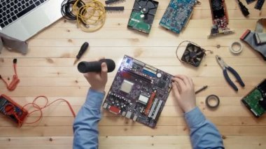 Üstten Görünüm bilgisayar teknisyeni araçları ve elektronik bileşenler ile ahşap masasında bir flaş ışığı ile anakart teftiş
