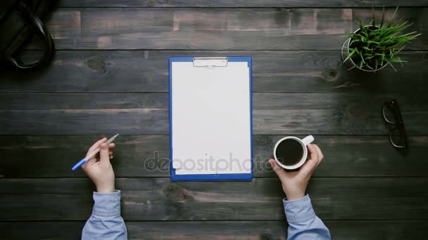 Pohled shora mužské ruce držící pero na stůl s schránky s papírem shora — Stock video