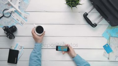 Beyaz ahşap masa başında smartphone kullanarak Dünya Haritası bakarak üstten görünüm yolcuları eller