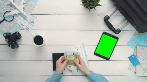 Concept voyageur Vue de dessus voyageurs mains vérifier l'argent et les billets et tablette numérique avec écran vert couché au bureau en bois blanc — Video