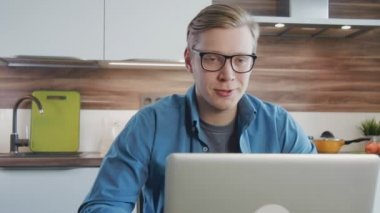 Genç adam evde onun dizüstü bilgisayar ile görüntülü sohbet sahip