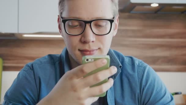 Νεαρός άνδρας χρησιμοποιώντας τηλέφωνο γραπτών μηνυμάτων χρησιμοποιώντας το κοινωνικό δίκτυο — Αρχείο Βίντεο