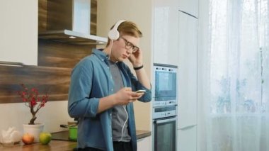 Mutlu delikanlı kulaklıklar giyen smartphone cep telefonu ile müzik dinlemek