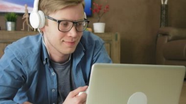 Kulaklık ile evde laptop akarsu film izlerken gülmekten genç adam