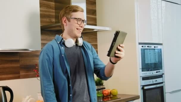 Młody mężczyzna o czat wideo przy użyciu cyfrowego tabletu w domu — Wideo stockowe