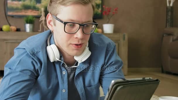 Ung man med en videochatt använder digitala tablett hemma — Stockvideo