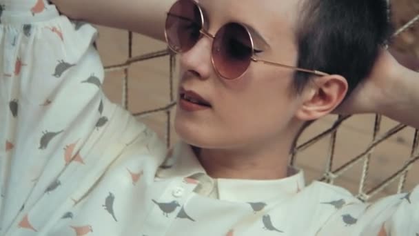 Woman With Short Hair Wearing Glasses Relaxing On The Hammock In