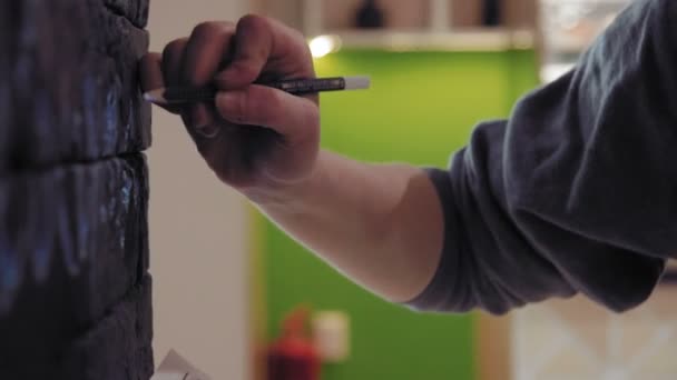 Genç kadın sanatçı siyah tuğla duvar kafede projektör kullanarak grafik tasarım aktarma kapatın — Stok video