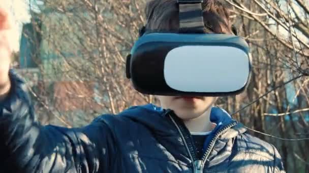 Close up of young boy wearing virtual reality headset in the backyard of his home — Stock Video