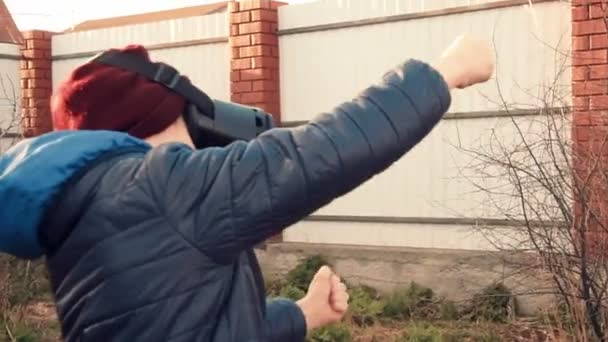 Niño jugando juego de carreras con auriculares de realidad virtual en el patio trasero — Vídeos de Stock