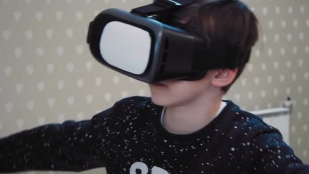 Liten pojke använder virtuell verklighet headset i flygsimulatorn — Stockvideo