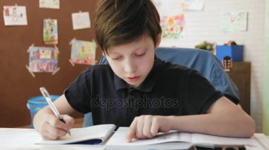 Sevimli küçük çocuk odasında öğrenci kitaptan egzersizleri yapıyor