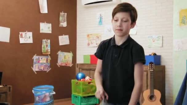 Sevimli küçük çocuk oyun su şişe çevirme meydan okuma odasında — Stok video