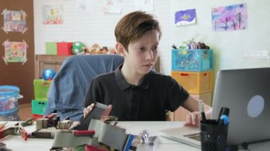 Sevimli küçük çocuk onarmak bilgisayar anakart ve dizüstü bilgisayardaki intructional manuel okuma diğer ayrıntıları