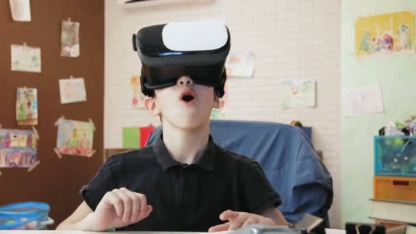 Милый мальчик, удивленный виртуальной реальностью — стоковое видео