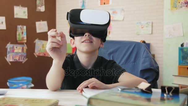 Милый мальчик разговаривает в видеочате с помощью гарнитуры виртуальной реальности — стоковое видео