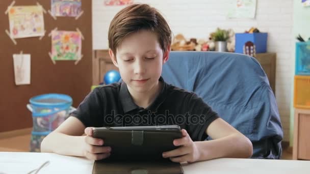 Χαριτωμένο μικρό αγόρι που παίζει το παιχνίδι στον υπολογιστή, χρησιμοποιώντας ψηφιακό tablet — Αρχείο Βίντεο