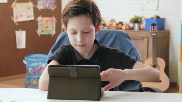 Cute little boy using digital tablet browsing the internet — Stock Video