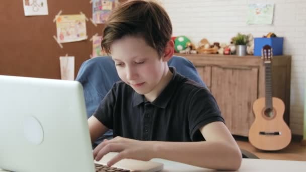 Cute little boy typing on keyboard of his laptop computer — Stock Video