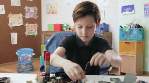 Cute little boy repairing computer motherboard attaching cooler — Stock Video