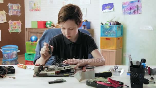 Cute little boy repairing computer motherboard and grphics card — Stock Video