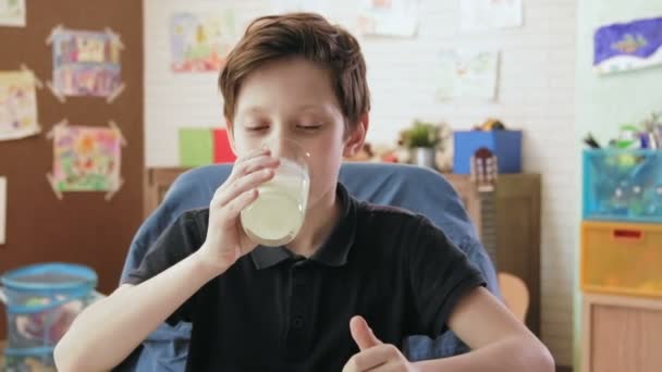 Carino bambino drinkng bicchiere di latte e mostra pollici su — Video Stock