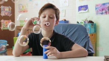 Sevimli çocuk kabarcıklar eğleniyor üfleme
