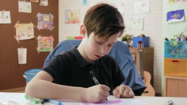 Sevimli çocuk araba resim çizer ve kameraya bakarak gösterir