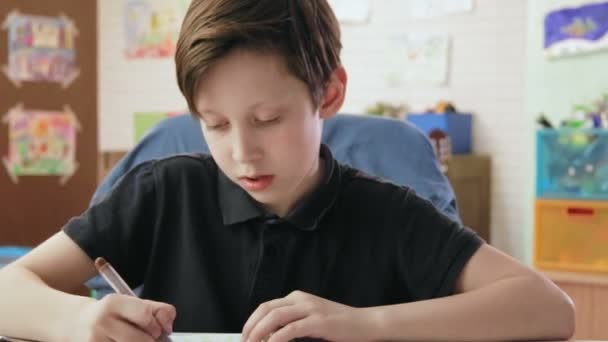 Cute boy draws in his room using felt-tip pen — Stock Video