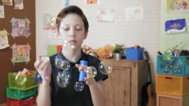 Sevimli çocuk kabarcıklar eğleniyor üfleme