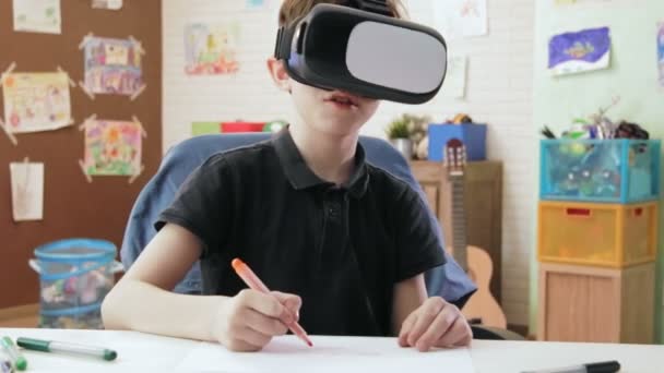 Χαριτωμένο αγόρι σχεδίασης χρησιμοποιώντας σετ κεφαλής εικονικής πραγματικότητας — Αρχείο Βίντεο