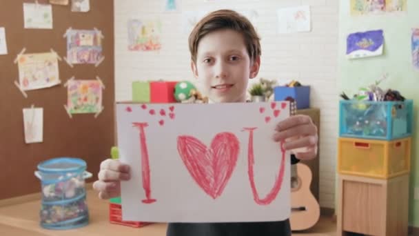 Χαριτωμένο αγόρι εικόνα δείχνει λέγοντας ότι αγαπώ το U κοιτάζοντας την κάμερα — Αρχείο Βίντεο