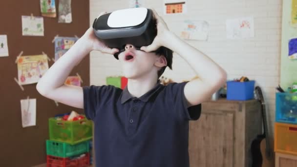 Söt pojke förvånad när du använder virtuell verklighet headset — Stockvideo