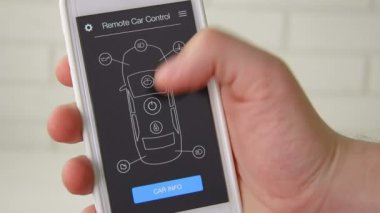 Adam uzaktan arabasının motoru başlatır. Araba uzaktan kumanda smartphone uygulama kurgusal arabirimini kullanarak.
