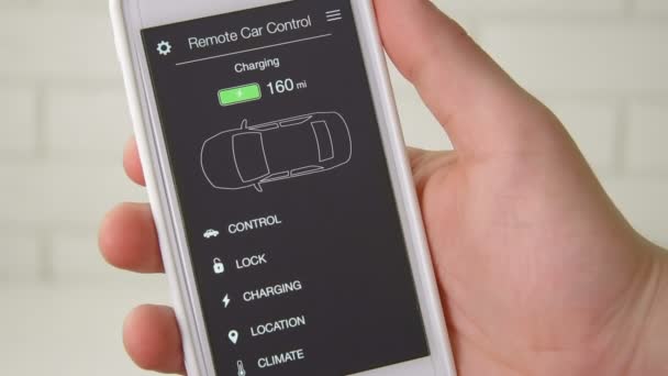 Man controleert laadniveau van zijn elektrische auto. Batterij is opgeladen. Auto-afstandsbediening met behulp van fictieve toepassingsinterface smartphone. — Stockvideo