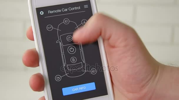 Man remotely starts engine of his car. Car remote control using smartphone application fictional interface. — Stock Video