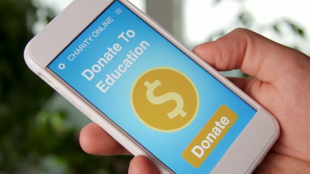 Homme faisant un don en ligne à l'éducation en utilisant application de charité sur smartphone — Video