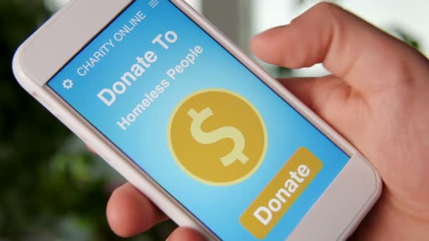 Man att göra en online donation till hemlösa med välgörenhet ansökan på smartphone — Stockvideo