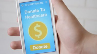 Healtcare sadaka uygulama smartphone kullanarak çevrimiçi bir bağış yapmayı adam