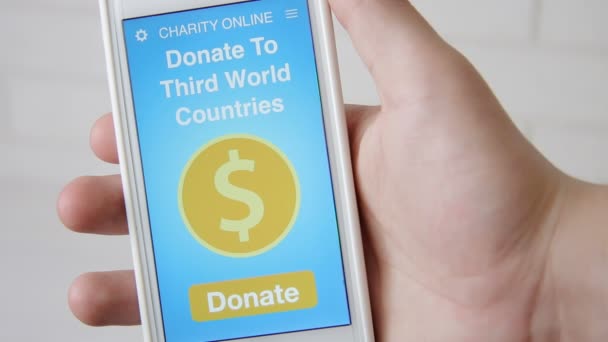 Man gör en online donation till länder i tredje världen med välgörenhet ansökan på smartphone — Stockvideo